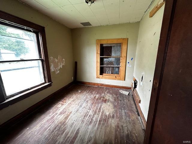 empty room featuring wood-type flooring and baseboards