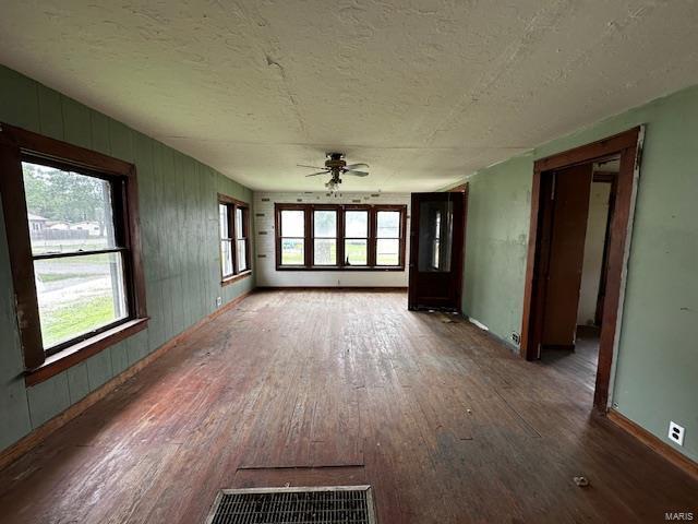 interior space featuring wood-type flooring, a textured ceiling, and a ceiling fan