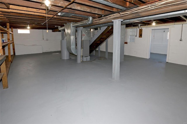 below grade area with electric panel, heating unit, and water heater