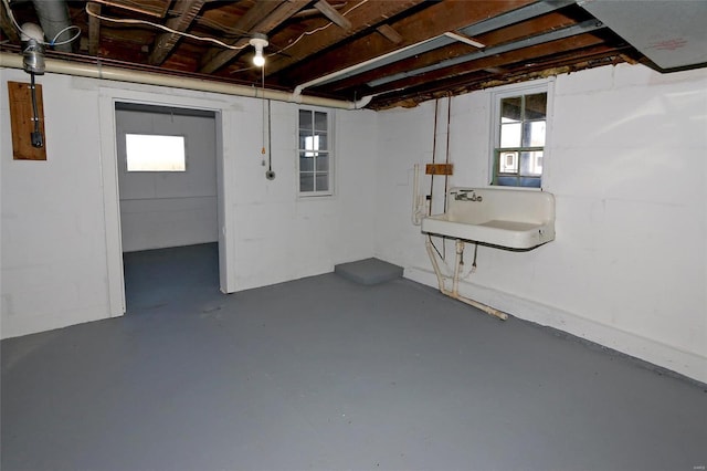 basement featuring a wealth of natural light and a sink