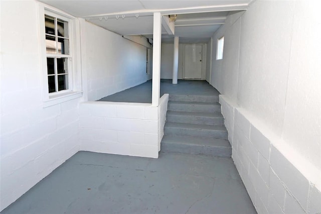 staircase with concrete block wall and concrete floors