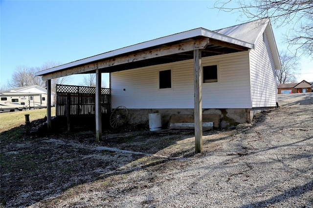 view of property exterior featuring a carport and metal roof