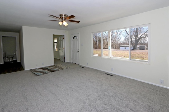 unfurnished living room with carpet, visible vents, and baseboards