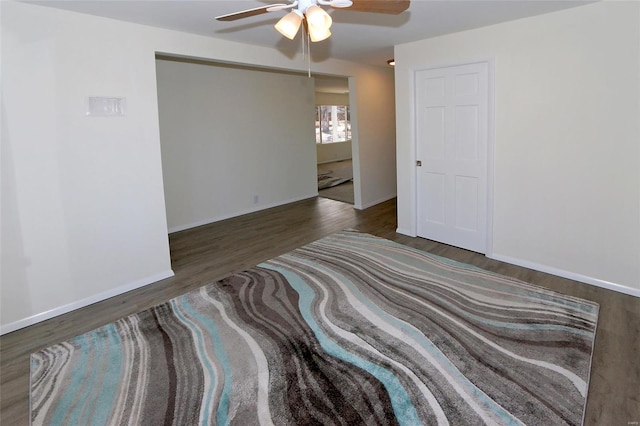 unfurnished room with ceiling fan, baseboards, and wood finished floors