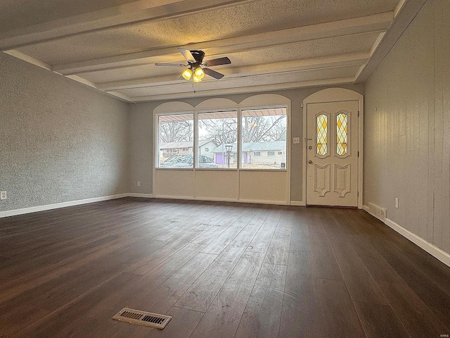 interior space with dark wood-style floors, beam ceiling, visible vents, and a ceiling fan