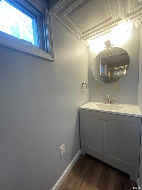 bathroom with vanity, baseboards, and wood finished floors