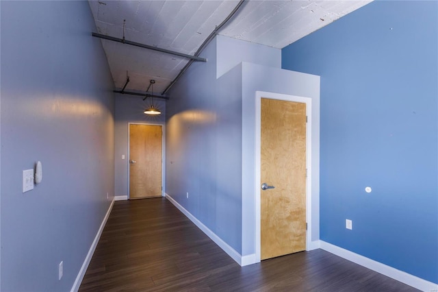 hall with baseboards and wood finished floors