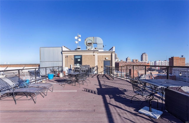 wooden terrace featuring a view of city and outdoor dining space