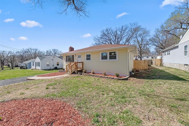 view of front of home featuring a front yard, a chimney, and fence