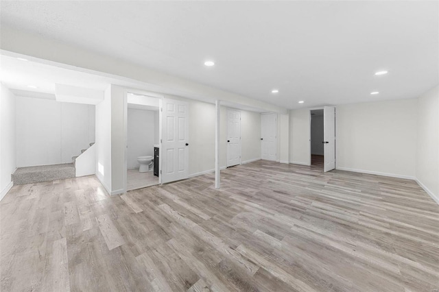 finished below grade area featuring stairway, recessed lighting, baseboards, and light wood-style floors