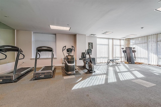 exercise room featuring expansive windows, visible vents, and baseboards