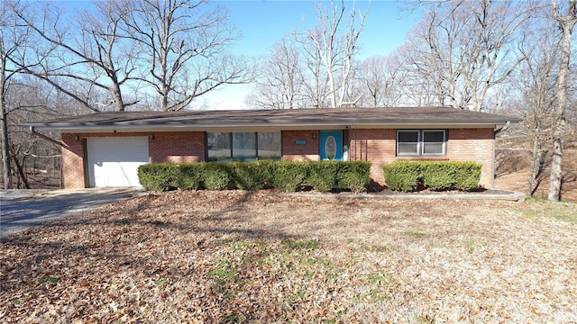 ranch-style home with an attached garage, driveway, and brick siding