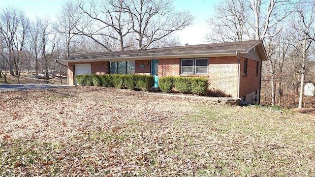 ranch-style house featuring a garage and brick siding