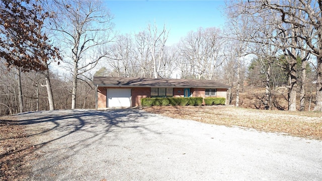 view of front of home featuring an attached garage, driveway, and brick siding