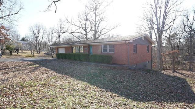 view of front of property with brick siding, driveway, and an attached garage