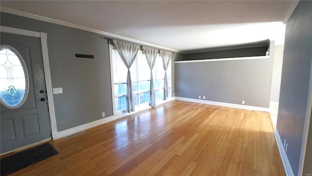 entryway with crown molding, baseboards, and wood finished floors