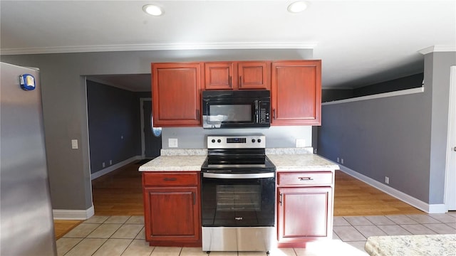 kitchen with ornamental molding, light countertops, appliances with stainless steel finishes, and light tile patterned flooring