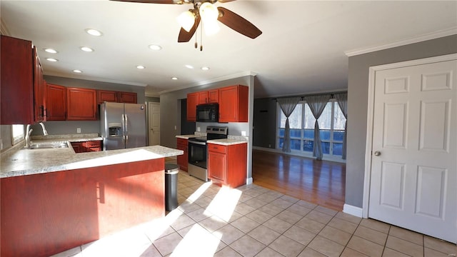 kitchen featuring a peninsula, stainless steel appliances, light countertops, a sink, and light tile patterned flooring