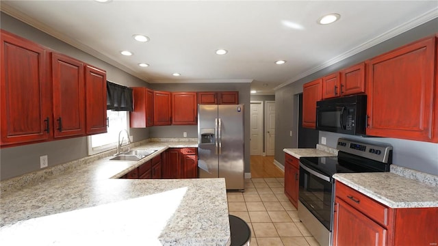 kitchen with reddish brown cabinets, light countertops, appliances with stainless steel finishes, and a sink