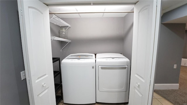 laundry room with light tile patterned floors, laundry area, independent washer and dryer, and baseboards