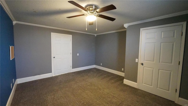 unfurnished bedroom featuring a ceiling fan, baseboards, dark colored carpet, and crown molding