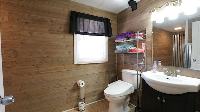 bathroom with tile patterned flooring, wooden walls, toilet, and vanity