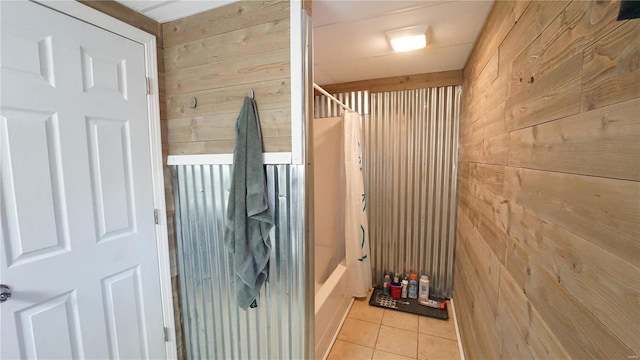 interior space featuring wood walls, tile patterned flooring, and shower / tub combo with curtain