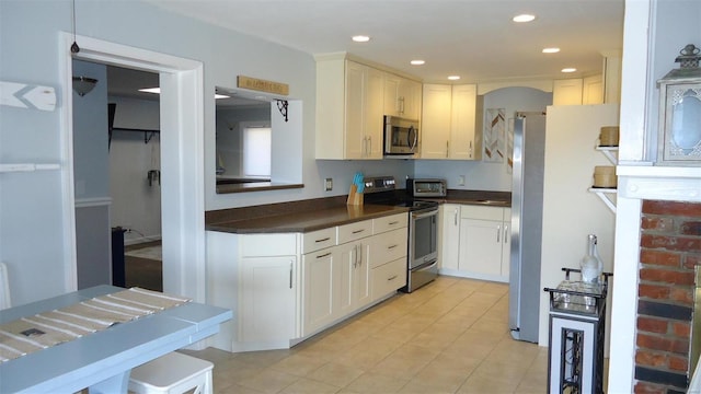 kitchen with dark countertops, white cabinetry, appliances with stainless steel finishes, and recessed lighting