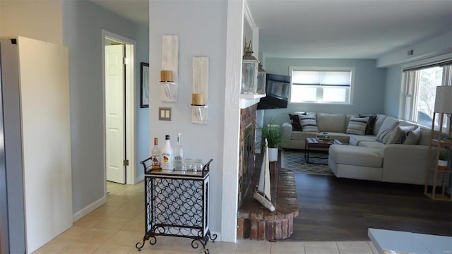 tiled living room with visible vents and a fireplace with raised hearth