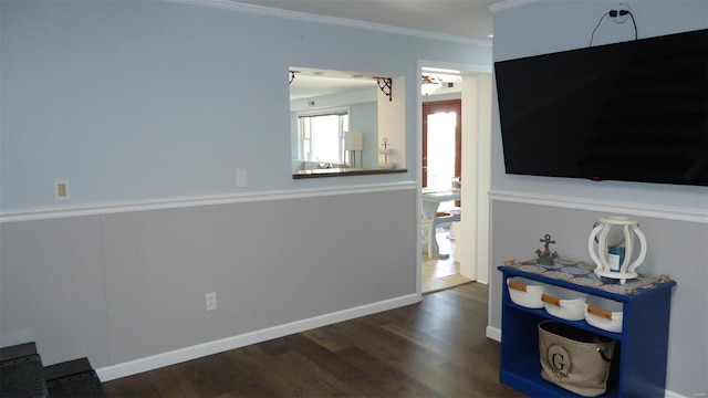 interior space featuring ornamental molding, wood finished floors, and baseboards