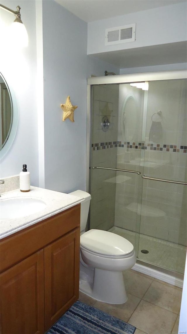 bathroom featuring visible vents, toilet, a stall shower, vanity, and tile patterned floors