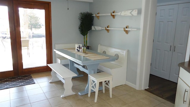 dining room with french doors, plenty of natural light, and light tile patterned floors