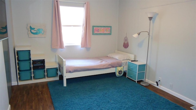 bedroom featuring dark wood finished floors and baseboards