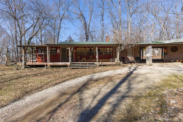 view of front of property featuring board and batten siding, a porch, and dirt driveway