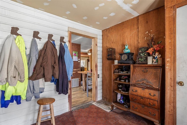 mudroom featuring wooden walls and visible vents