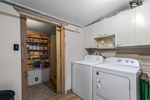 clothes washing area featuring washing machine and clothes dryer and cabinet space