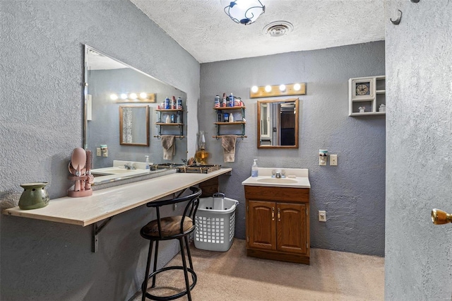 bathroom featuring a textured ceiling, a textured wall, and visible vents