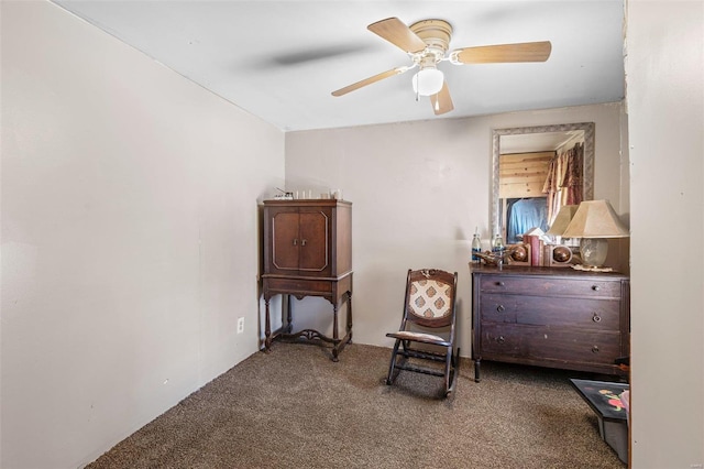 living area featuring a ceiling fan and carpet