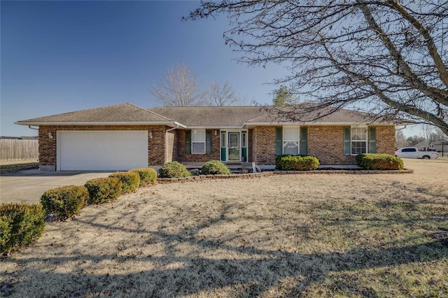 ranch-style house with a garage, concrete driveway, brick siding, and fence