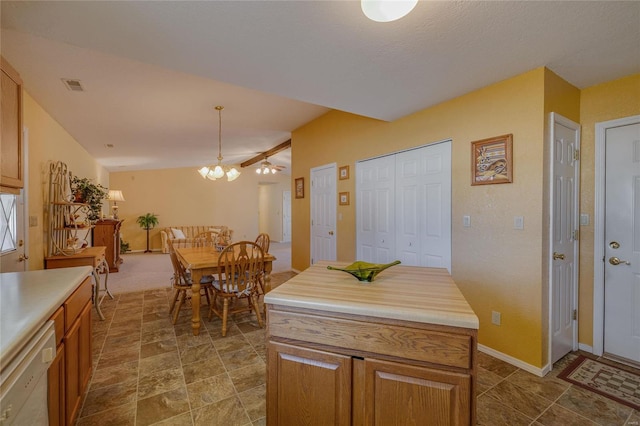 kitchen with dishwasher, light countertops, brown cabinetry, and visible vents