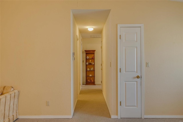 hall featuring carpet, visible vents, and baseboards