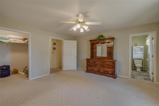 unfurnished bedroom featuring ensuite bath, carpet, baseboards, and ceiling fan