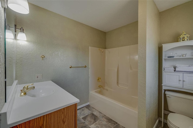 full bath with baseboards, a textured wall, toilet, vanity, and washtub / shower combination