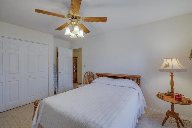 carpeted bedroom with ceiling fan, a closet, and baseboards