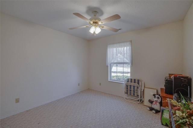 unfurnished room featuring a ceiling fan and carpet flooring