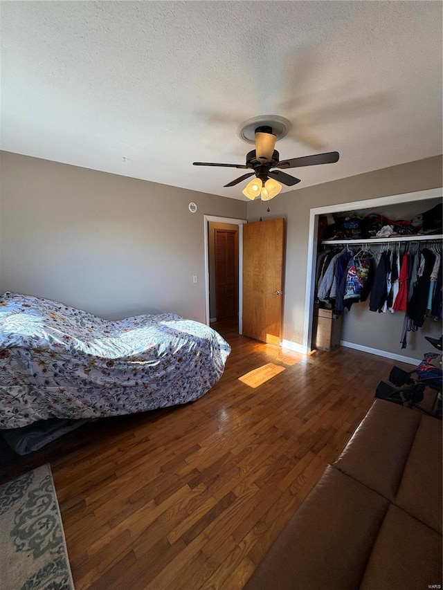 bedroom featuring a textured ceiling, ceiling fan, a closet, and wood finished floors