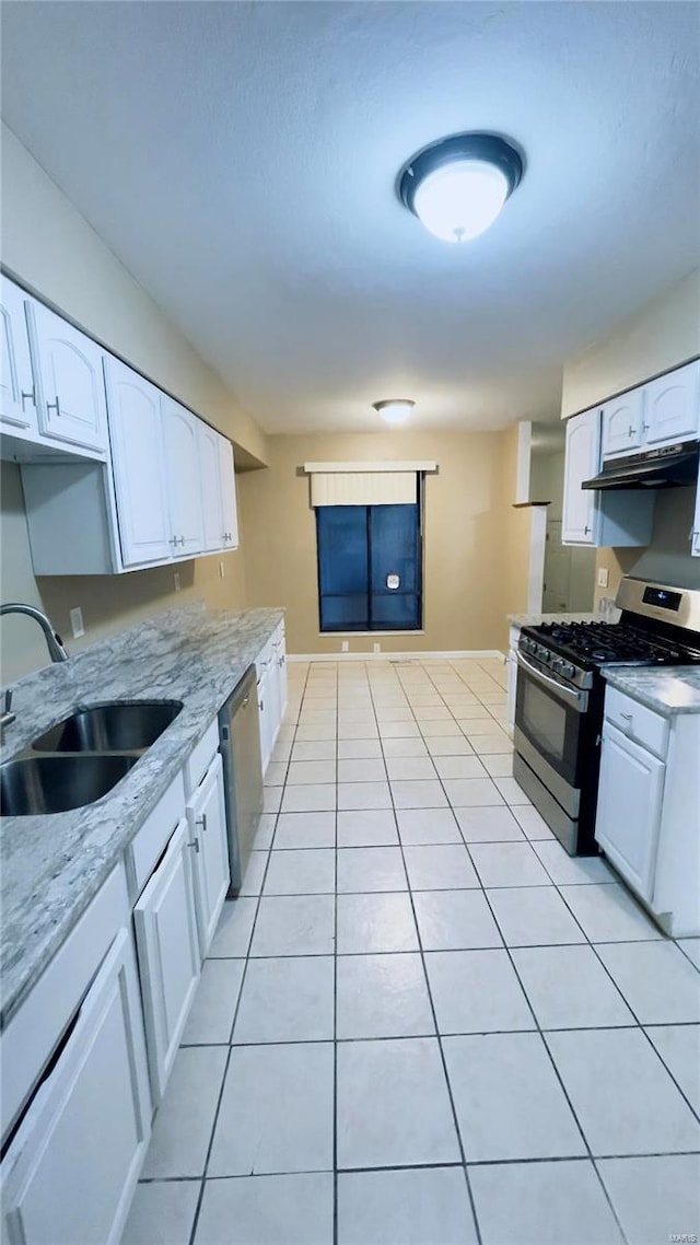 kitchen featuring light tile patterned floors, stainless steel appliances, white cabinetry, a sink, and under cabinet range hood