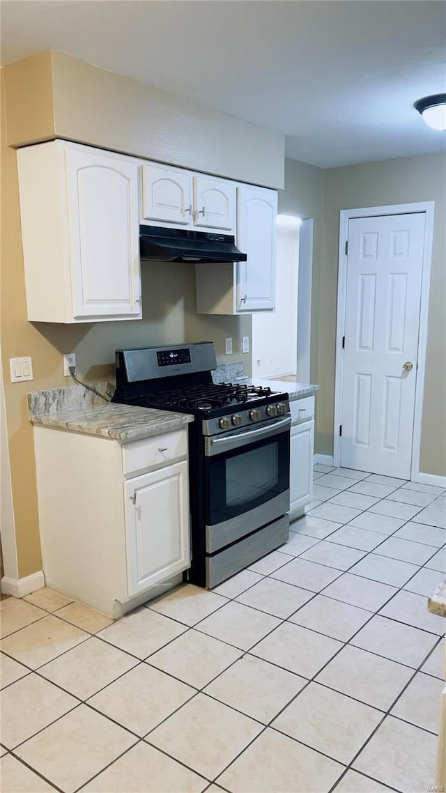 kitchen featuring light tile patterned floors, under cabinet range hood, white cabinets, light countertops, and stainless steel gas range