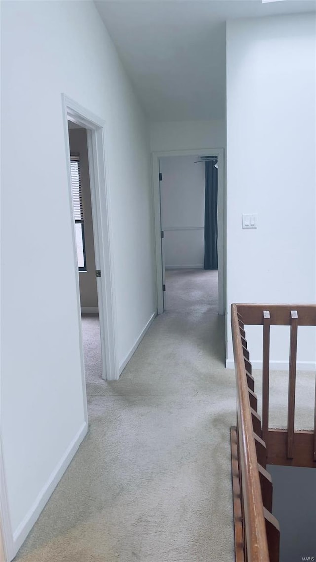 hall with vaulted ceiling, carpet floors, and baseboards