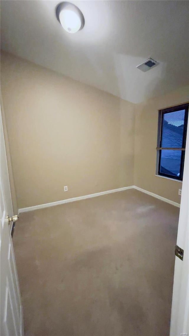 spare room with carpet floors, visible vents, and baseboards